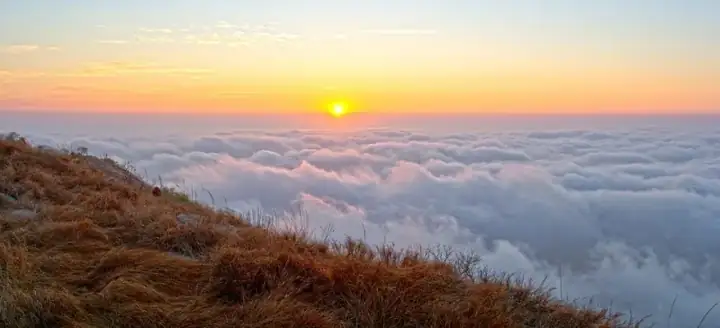 Sun rising over a blanket of clouds, Nandi Hills, Karnataka