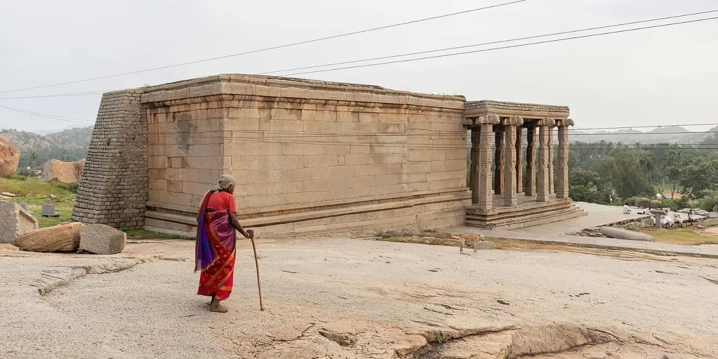 An elderly woman walking towards Kadalekalu Ganesha Temple
