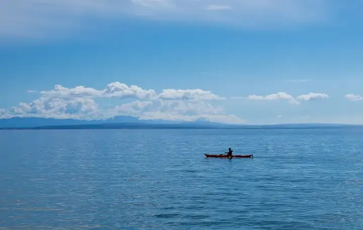 Man paddling on kayak in turquoise water