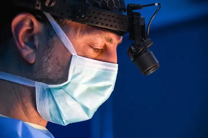 Facial Plastic Surgeon Using Surgical Loupes and Headlight During Procedure